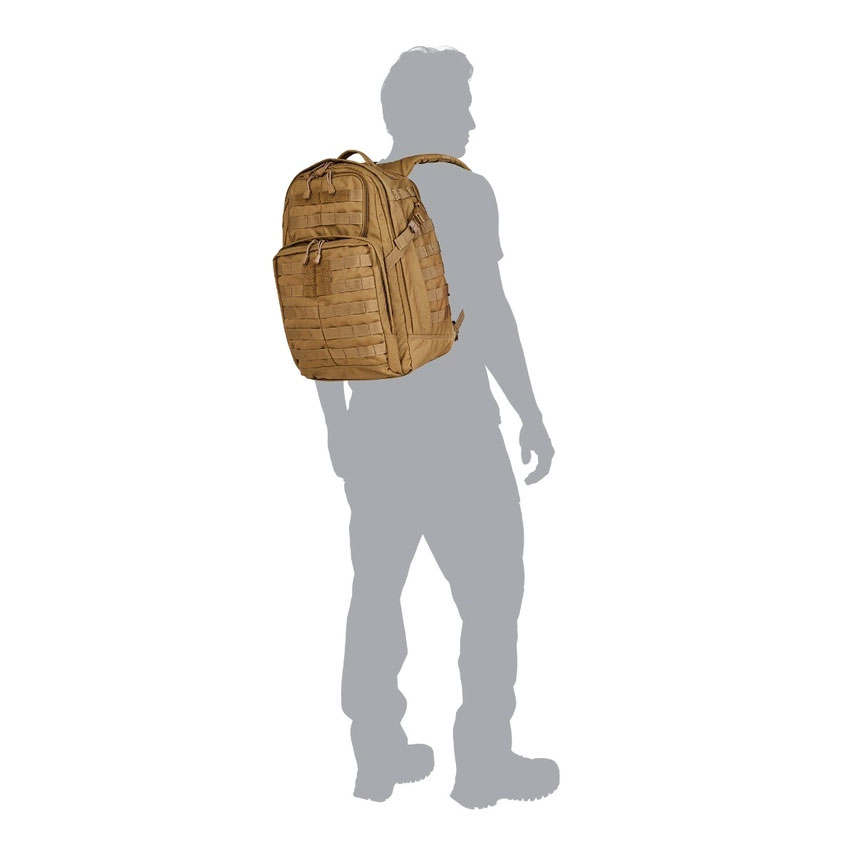 A man standing in front of a backpack.