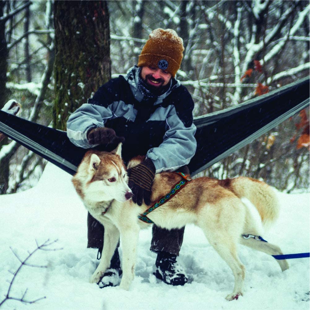 A man and his dog in the snow.